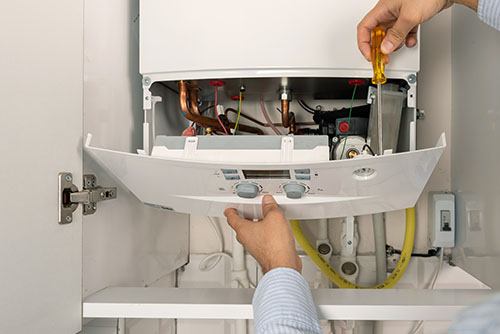 Heating technician repairing a residential boiler in Lodi