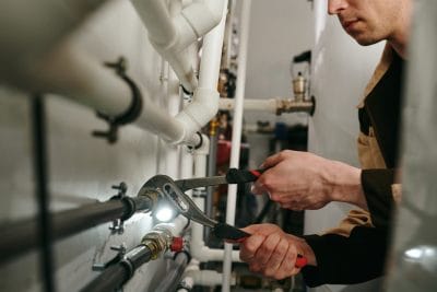 Technician inspecting commercial plumbing pipes in Lodi
