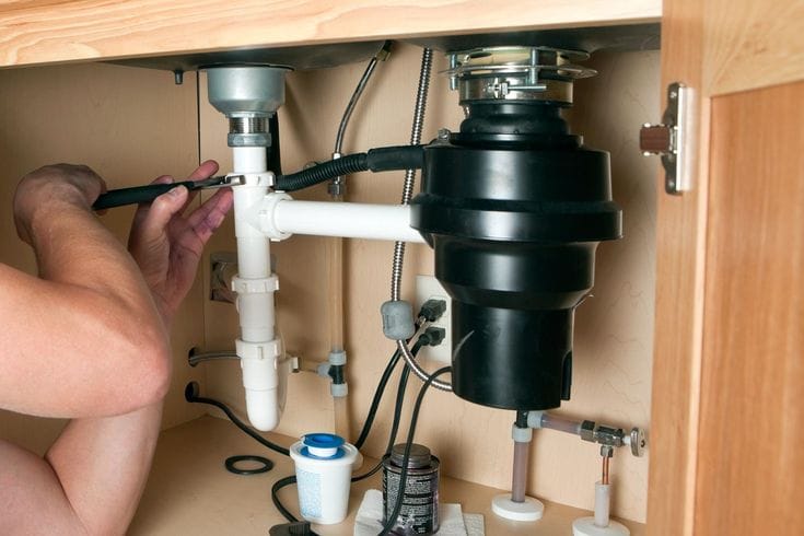Plumber repairing a garbage disposal in Lodi