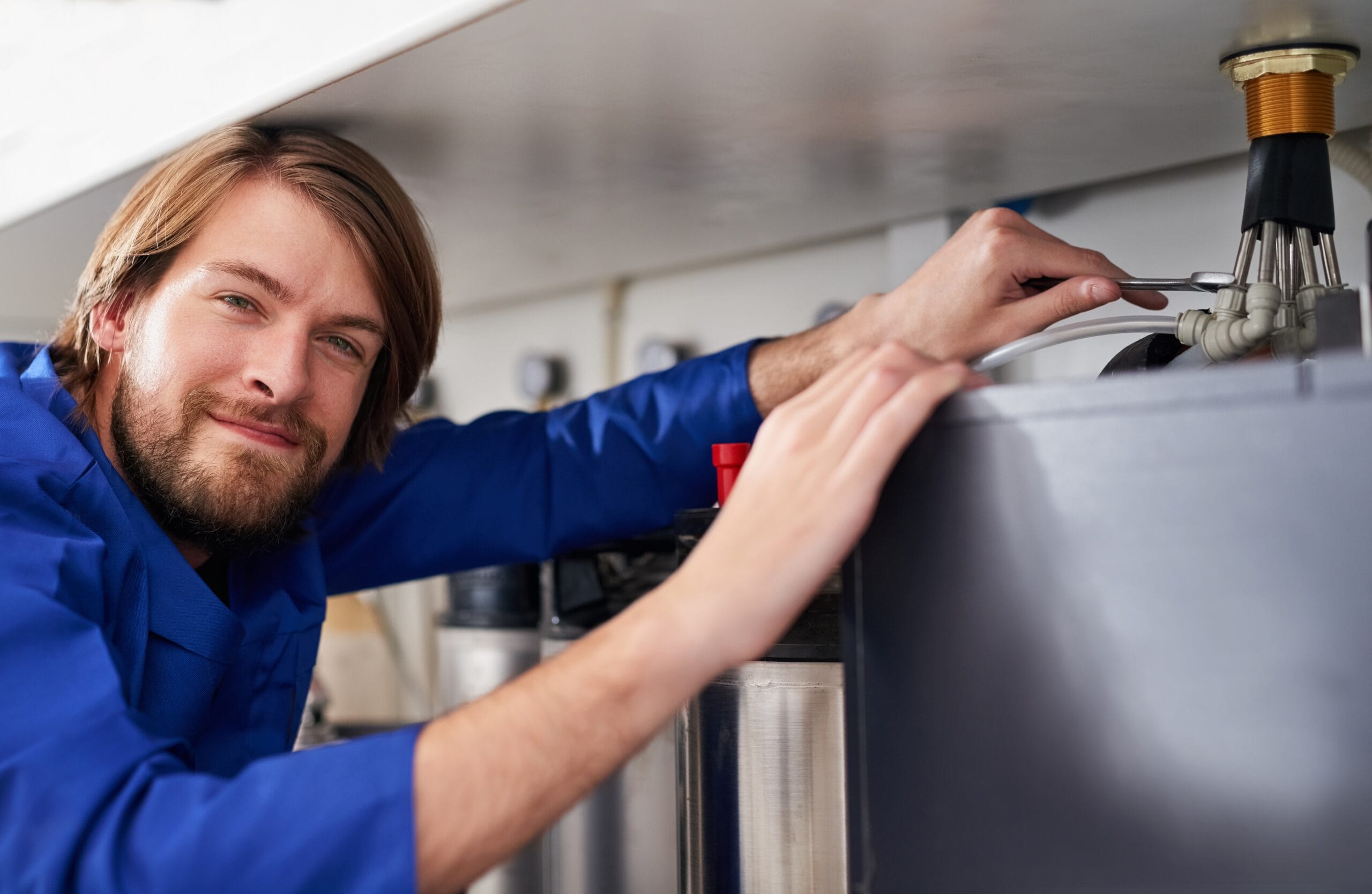 Technician servicing a residential water heater tank in Lodi